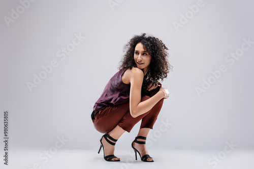 Fashion model crouching and looking over shoulder photo