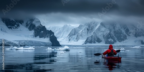 A woman kayaking on a tranquil lake surrounded by snow-capped mountains, embracing nature and adventure in a scenic outdoor winter setting photo