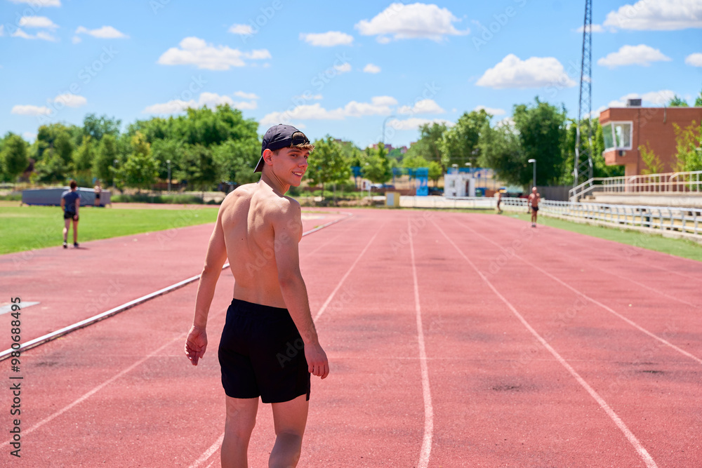 Fototapeta premium Smiling athlete walking on track during training