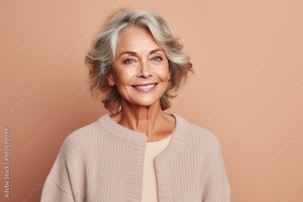 Portrait of a jovial woman in her 60s wearing a classic turtleneck sweater isolated on pastel brown background Portrait of a jovial woman in her 60s wearing a classic turtleneck sweater isolated on pastel brown background