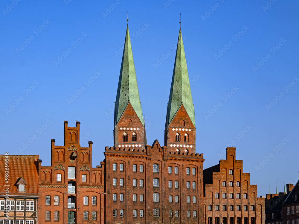 Blick auf die Türme der Kirche St. Marien zwischen den Fassaden historischer Häuser in der Altstadt von Lübeck, Deutschland Blick auf die Türme der Kirche St. Marien zwischen den Fassaden historischer Häuser in der Altstadt von Lübeck, Deutschland