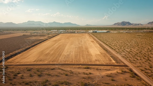 Aerial view of a commercial land plot marked by boundary lines, set against open land and clear skies. Copy space available. photo