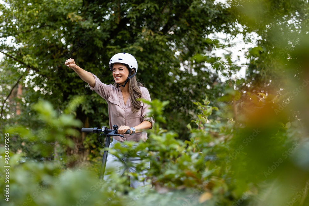 Smiling woman in park supporting green energy and riding electric scooter. Smiling woman in park supporting green energy and riding electric scooter.