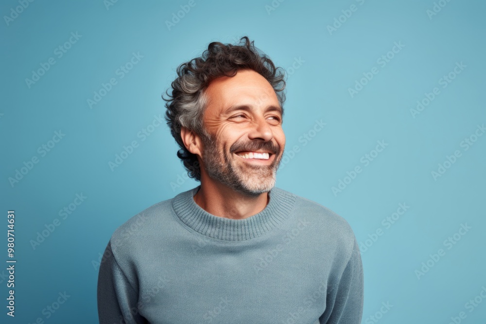 Portrait of a cheerful man in his 40s wearing a thermal fleece pullover on soft blue background Portrait of a cheerful man in his 40s wearing a thermal fleece pullover on soft blue background
