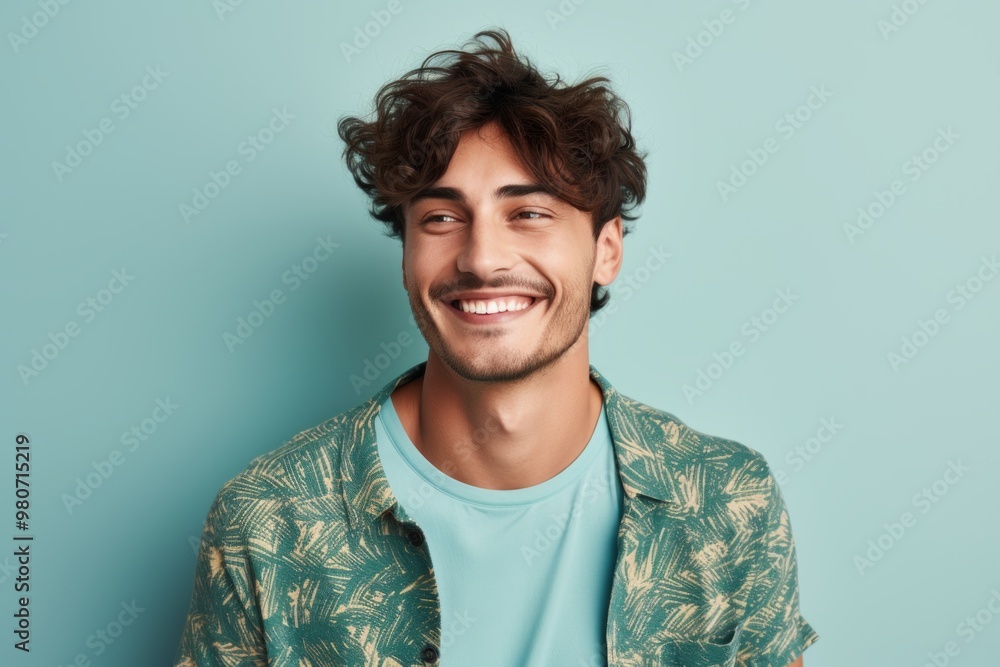 Portrait of a satisfied man in his 20s donning a trendy cropped top while standing against soft blue background Portrait of a satisfied man in his 20s donning a trendy cropped top while standing against soft blue background