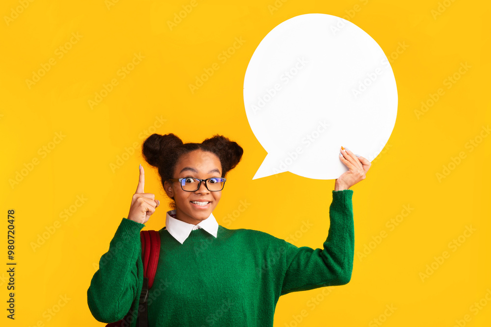 I Have An Idea. African american girl holding blank speech bubble, raising finger over yellow background I Have An Idea. African american girl holding blank speech bubble, raising finger over yellow background