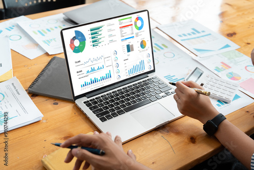 Business Team Analyzing Financial Data on Laptop with Charts and Graphs in Office Meeting