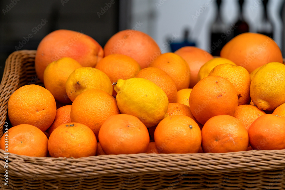 A basket of oranges, tangerines and lemons at the market in closeup