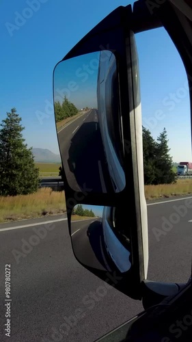 Rearview Mirror Perspective: Road and Traffic Behind Truck