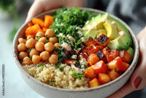 A vibrant, healthy bowl of quinoa topped with chickpeas, roasted vegetables, and fresh greens, perfect for a nutritious meal.