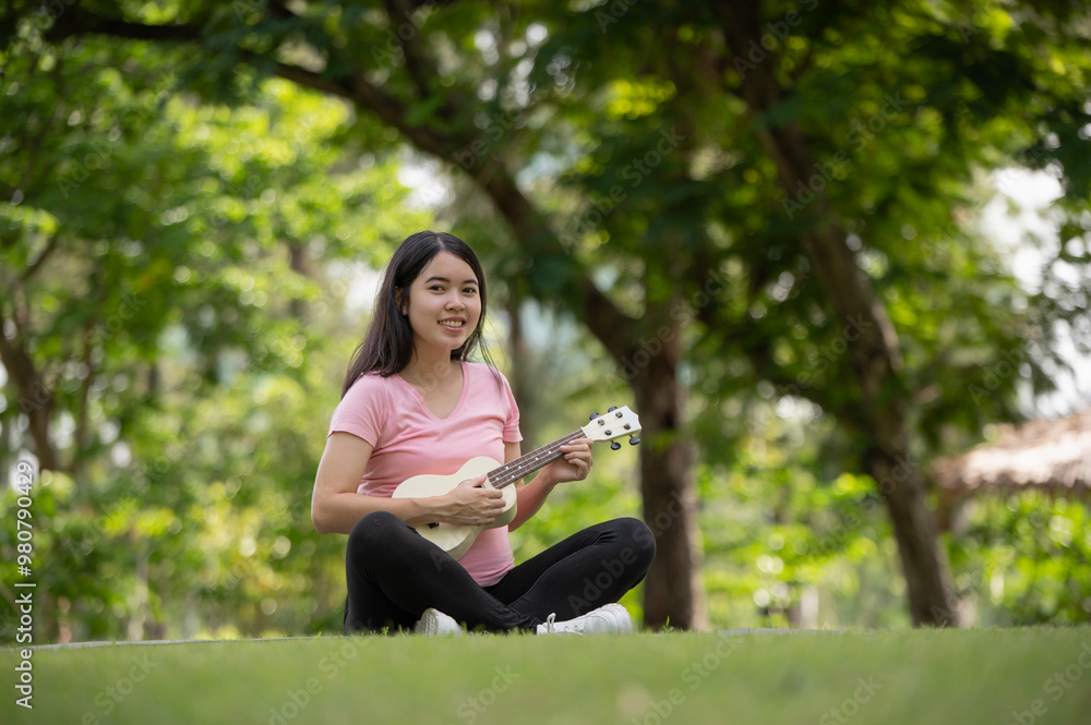 Asian healthy pregnant woman enjoying and relaxing by playing Ukulele in the park, Music time Asian healthy pregnant woman enjoying and relaxing by playing Ukulele in the park, Music time