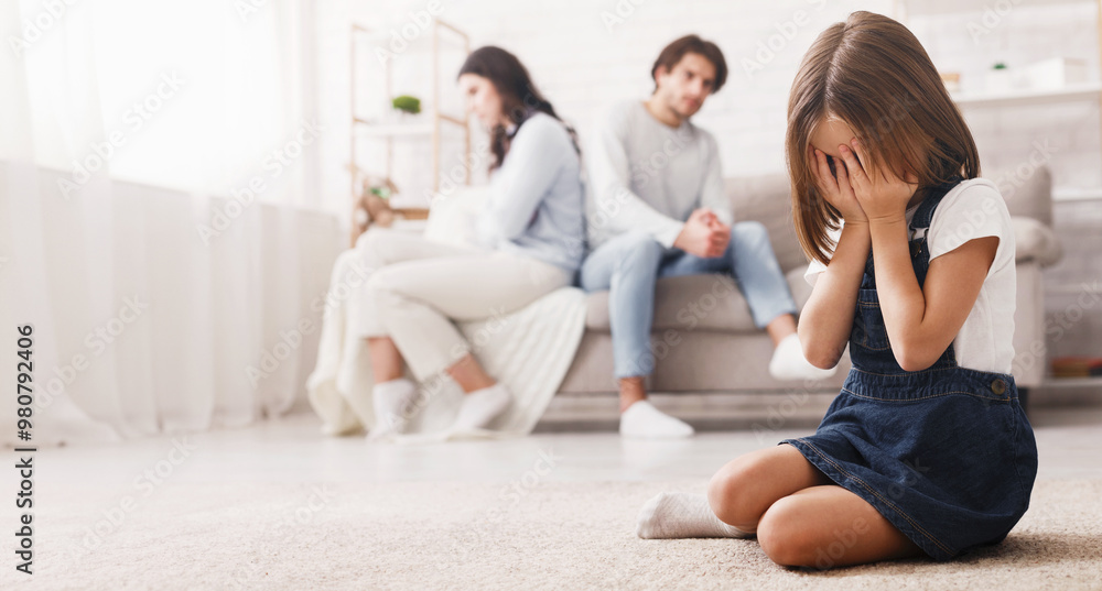 Family problems concept. Crying little girl sitting separately from parents after their arguing, upset kid tired of quarrels, feeling lonely Family problems concept. Crying little girl sitting separately from parents after their arguing, upset kid tired of quarrels, feeling lonely