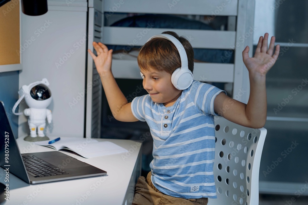 caucasian little boy wearing wireless headphones studying at home using laptop caucasian little boy wearing wireless headphones studying at home using laptop