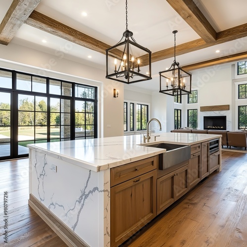 Traditional kitchen in beautiful new luxury home with hardwood floors, wood beams, and large island quartz counters. Includes farmhouse sink, elegant pendant lights, and large windows.