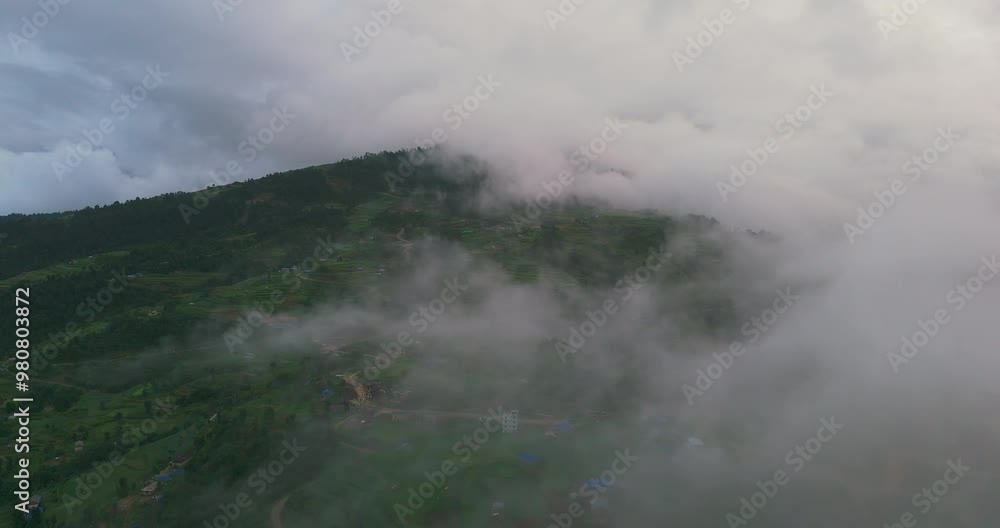Drone shot capturing Nepali village in Dolakha clouds over rolling hills in both sunny and gloomy weather. The scene shows uniquely amazing greenery and serene beauty of landscape. Drone shot capturing Nepali village in Dolakha clouds over rolling hills in both sunny and gloomy weather. The scene shows uniquely amazing greenery and serene beauty of landscape.