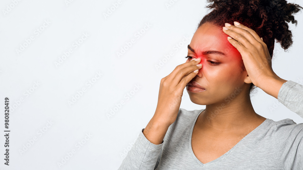 Exhausted afro woman rubbing nose and head, suffering from sinusitis, grey background, copy space Exhausted afro woman rubbing nose and head, suffering from sinusitis, grey background, copy space
