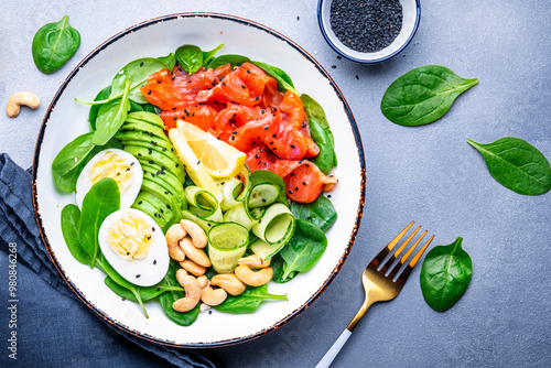 Photography Keto diet salad with salmon, avocado, spinach, eggs and cashew