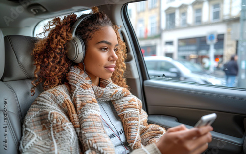 A young woman wearing headphones and relaxing in a car while listening to music, capturing a moment of tranquility and escape during a journey photo