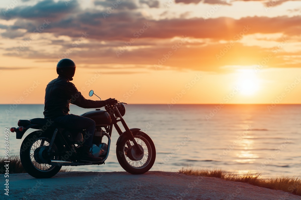 A man is riding a motorcycle on a road near the ocean. The sky is orange and the sun is setting A man is riding a motorcycle on a road near the ocean. The sky is orange and the sun is setting