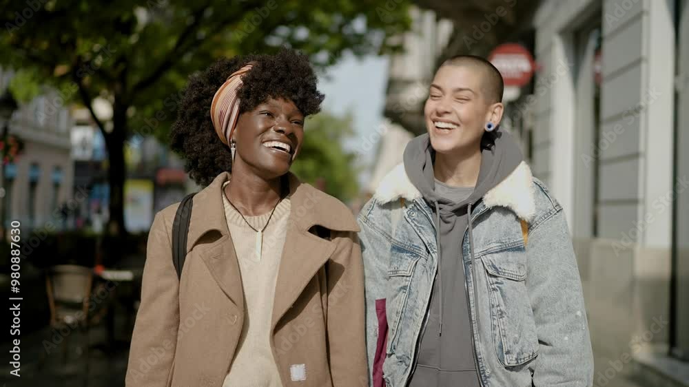 Smiling young diverse lesbian couple walking downtown and shopping Smiling young diverse lesbian couple walking downtown and shopping