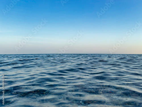 Calm sea under a blue sky at sunrise. calm colors. waterline. waves. ripples. sea water surface. 