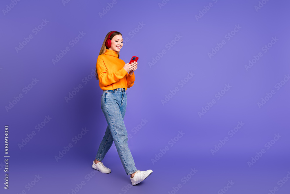 Photo portrait of blonde hair cheerful youngster girl using her smartphone chatting walking listen music isolated on purple color background Photo portrait of blonde hair cheerful youngster girl using her smartphone chatting walking listen music isolated on purple color background
