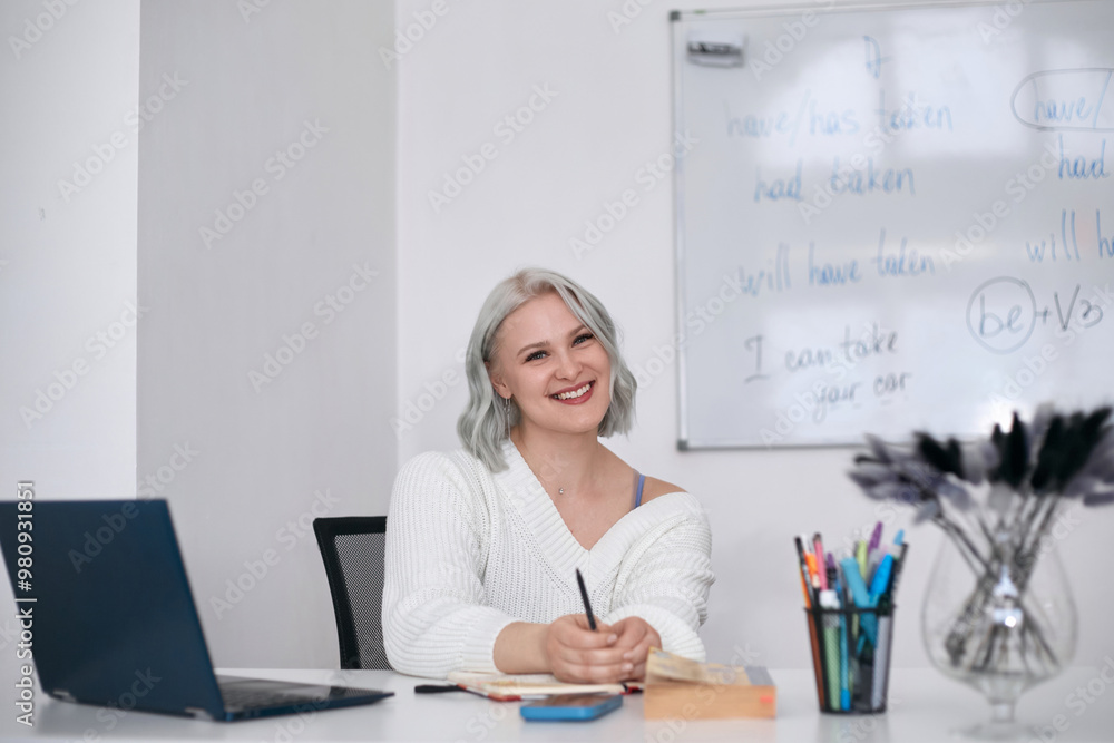 A young English teacher in his office at work. Additional education and retraining A young English teacher in his office at work. Additional education and retraining