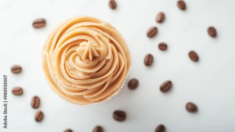 Delicious coffee-flavored cupcake with creamy frosting and scattered coffee beans on a white background. Delicious coffee-flavored cupcake with creamy frosting and scattered coffee beans on a white background.