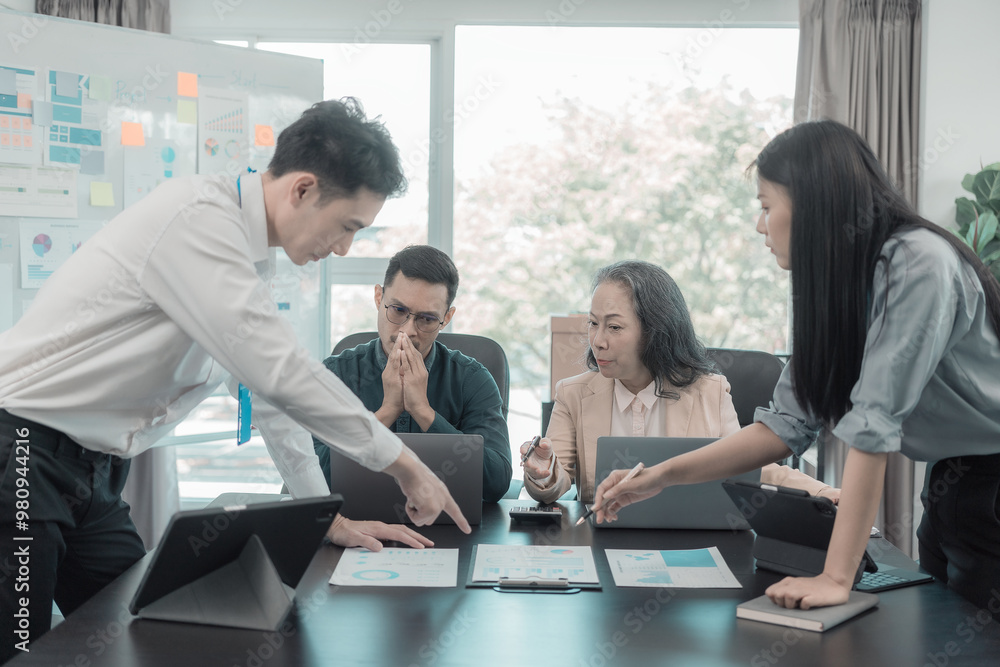Group of Asian business people in conference room for business presentation or seminar. Documents have financial or marketing figures, graphs and charts. There is a laptop to analyze company stocks. Group of Asian business people in conference room for business presentation or seminar. Documents have financial or marketing figures, graphs and charts. There is a laptop to analyze company stocks.