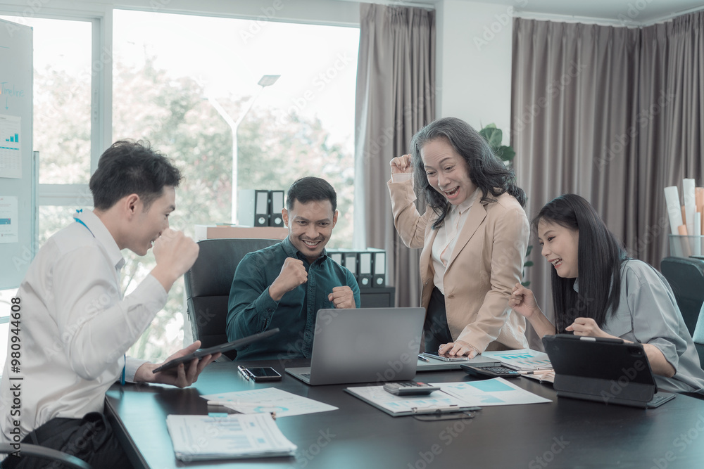 A diverse group of business professionals gather at a conference table in an office to celebrate a business victory, a good sales result, and achieving a financial goal. A diverse group of business professionals gather at a conference table in an office to celebrate a business victory, a good sales result, and achieving a financial goal.