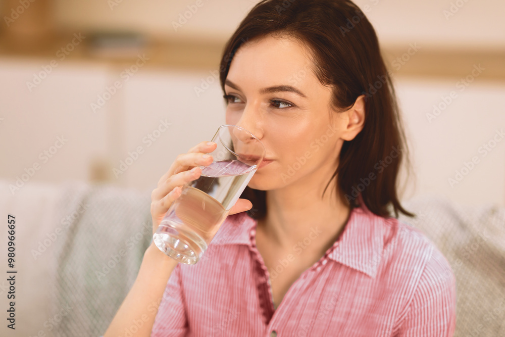 Stay Hydrated. Smiling healthy girl drinking clean mineral water from glass before breakfast, copyspace, close up