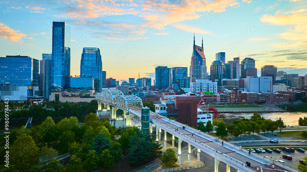 Fototapeta premium Aerial View of Nashville Skyline with Sunset Over Pedestrian Bridge