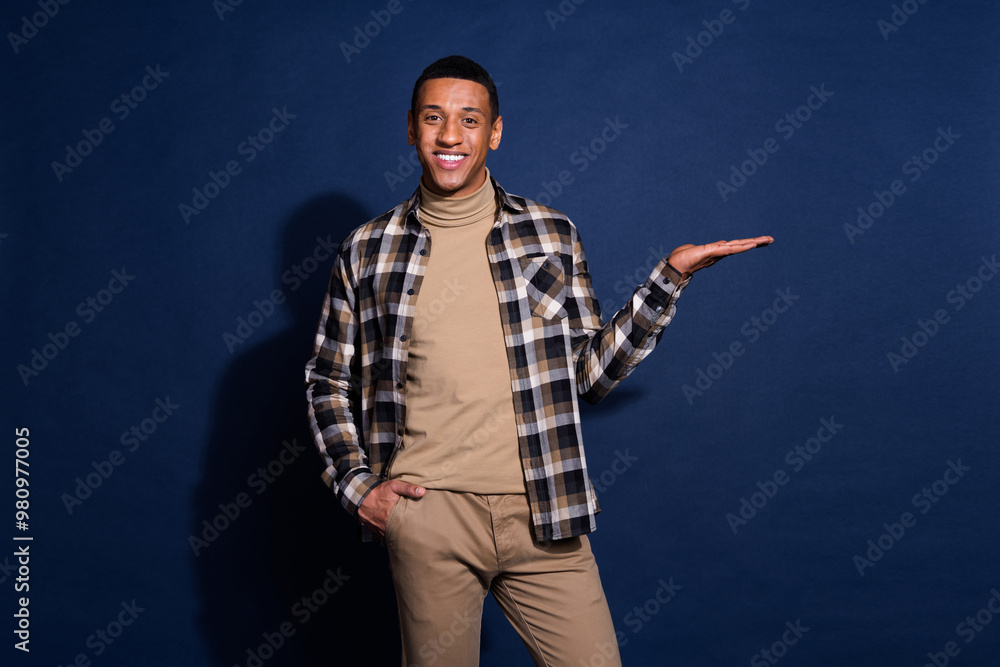 Photo of attractive young man hold empty space hand pocket dressed stylish checkered clothes isolated on dark blue color background Photo of attractive young man hold empty space hand pocket dressed stylish checkered clothes isolated on dark blue color background