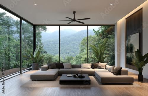 Modern living room interior with a large window and a tropical forest view, white walls, wooden floor, a grey sofa, a black coffee table, a ceiling fan