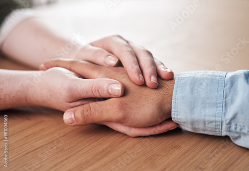 Love, support and people holding hands on table for marriage, kindness and understanding at home. Couple, trust and connection with compassion in commitment for partnership, forgiveness and comfort photo