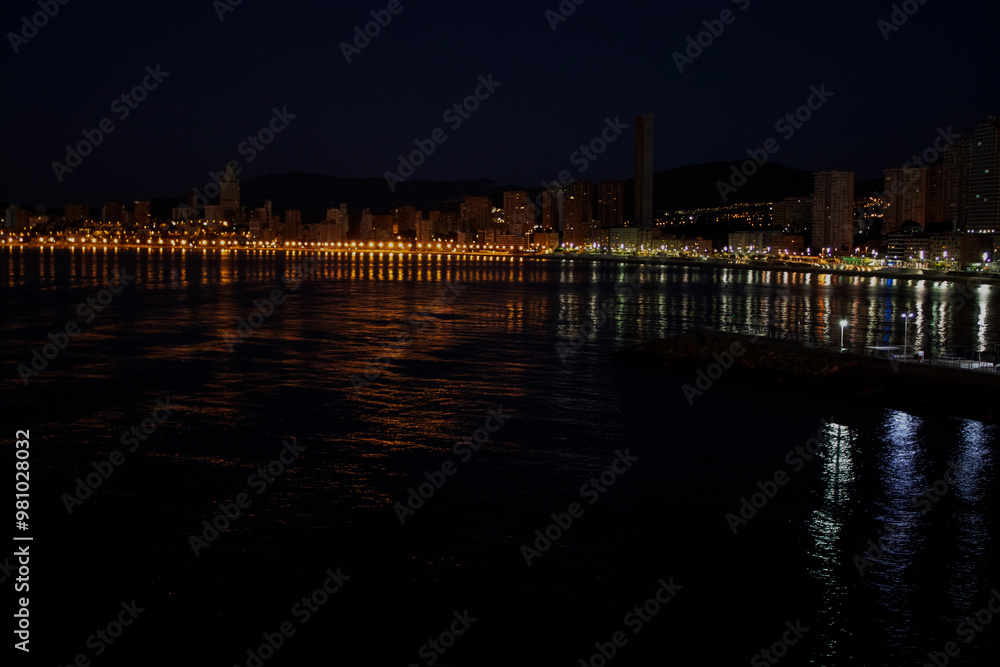Fototapeta premium Night Aerial photo of Benidorm Playa Levante beach, hotels, buildings, restaurants and the coastline and sandy beaches of Benidorm the seaside resort in Spain Alicante.