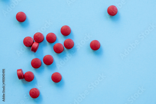 a scattering of red round tablets on a bright blue background