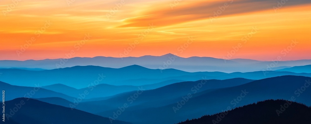 Obraz premium Sunset over layered mountain range with vibrant