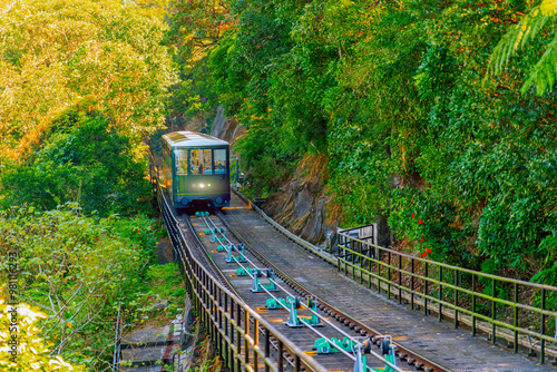 The famous green tram on the slope of Victoria Peak in Hong Kong passes, lifting visitors to the observation deck at the top