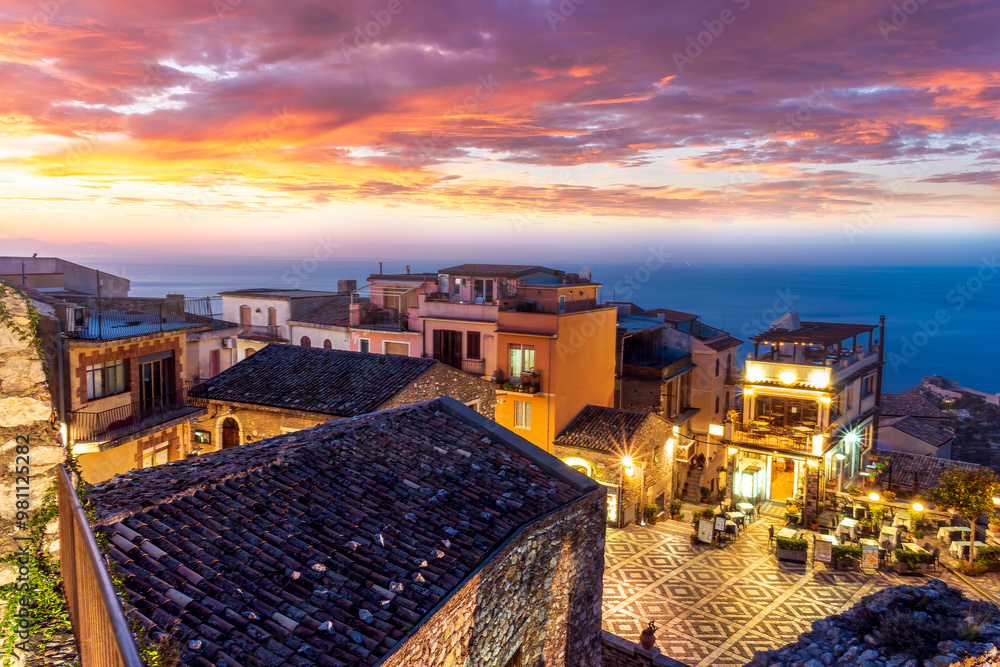 Fototapeta premium beautiful travel town view from a mountain to roofs and houses, valley and sea gulf with scenic cloudy sunrise or sunset on background of landscape