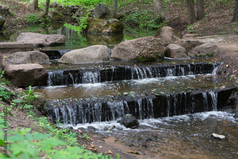 small artificial waterfall on a stream in a city park. Minsk, Belarus