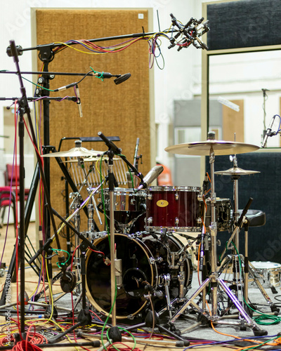 A professional drum set equipped with multiple microphones in a recording studio environment. photo