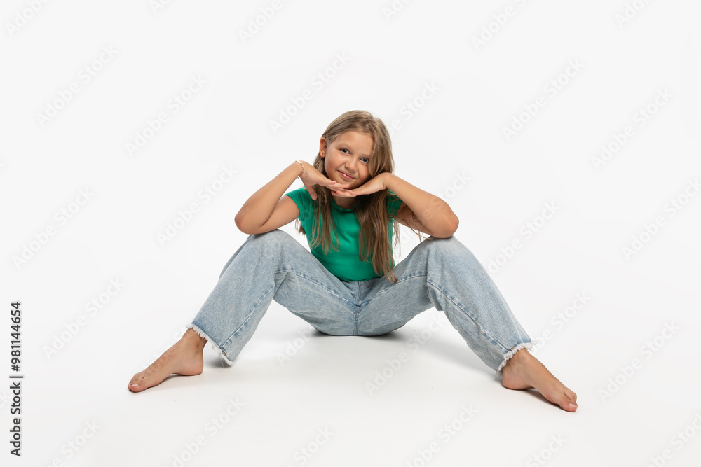 Girl with blonde hair posing and sitting on floor, in studio, over white background. Girl with blonde hair posing and sitting on floor, in studio, over white background.