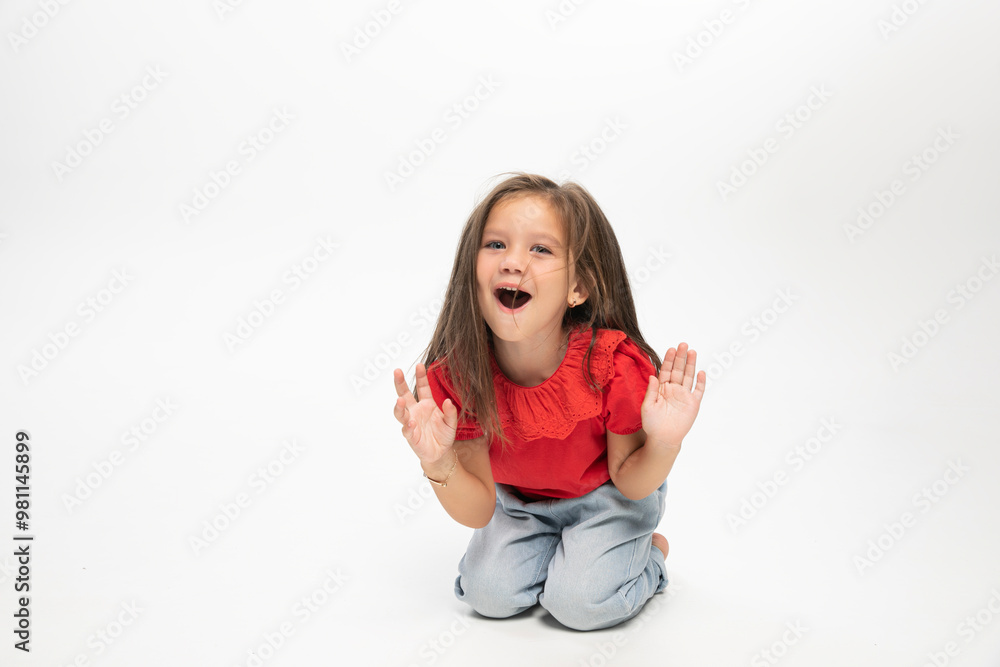 Amased little girl posing on floor, white background. Space for text. Amased little girl posing on floor, white background. Space for text.