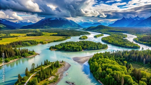 * The Kenai River winds its way through a lush, green valley, surrounded by towering mountains, as the tide rolls in on a sunny July day.