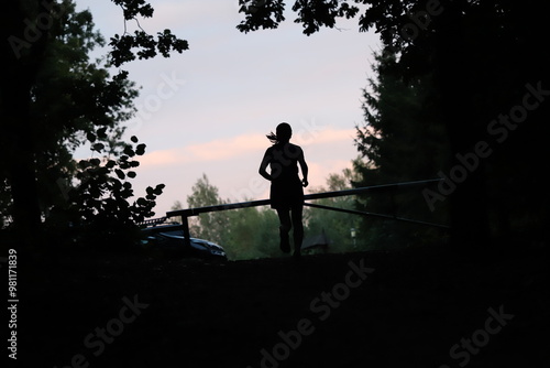 silhouette of a runner at the barrier and trees