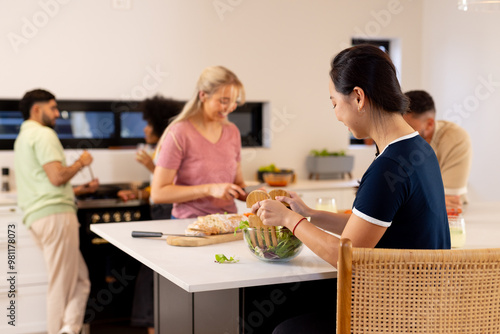 Preparing food together, group of young diverse friends enjoying time in kitchen