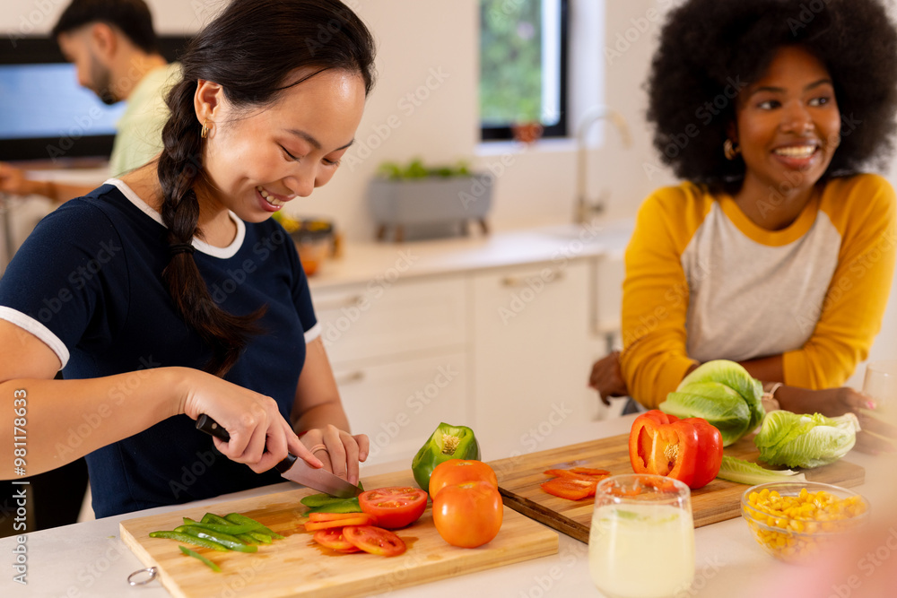© wavebreak3 - Chopping vegetables, woman smiling while preparing meal with diverse friends in kitchen © wavebreak3 - Chopping vegetables, woman smiling while preparing meal with diverse friends in kitchen