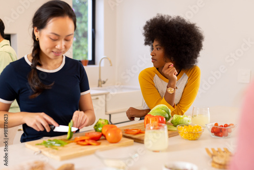 Preparing vegetables, diverse friends cooking together in modern kitchen