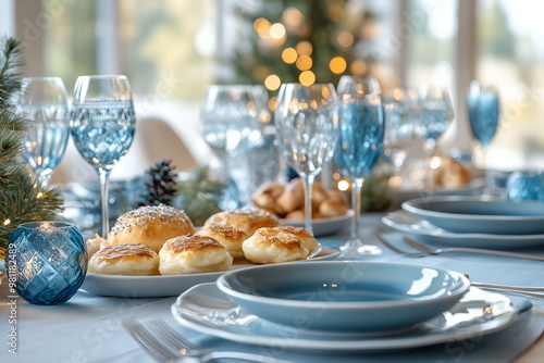 A table set for Hanukkah with latkes, sufganiyot, dreidels, arranged with blue and silver decorations photo